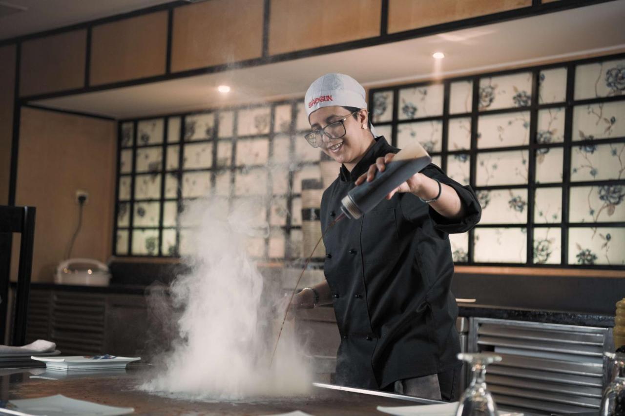 Radisson Blu Hotel, Riyadh Exterior photo A chef dusting a dish with powdered sugar